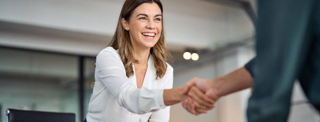 The image depicts a handshake following the agreement of a staff employment contract between the new employer and employer.